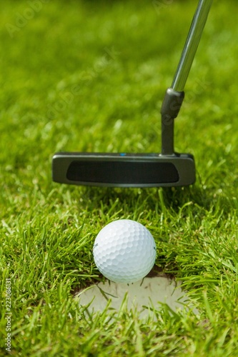 Putter Pushing a Golf Ball in a Hole
