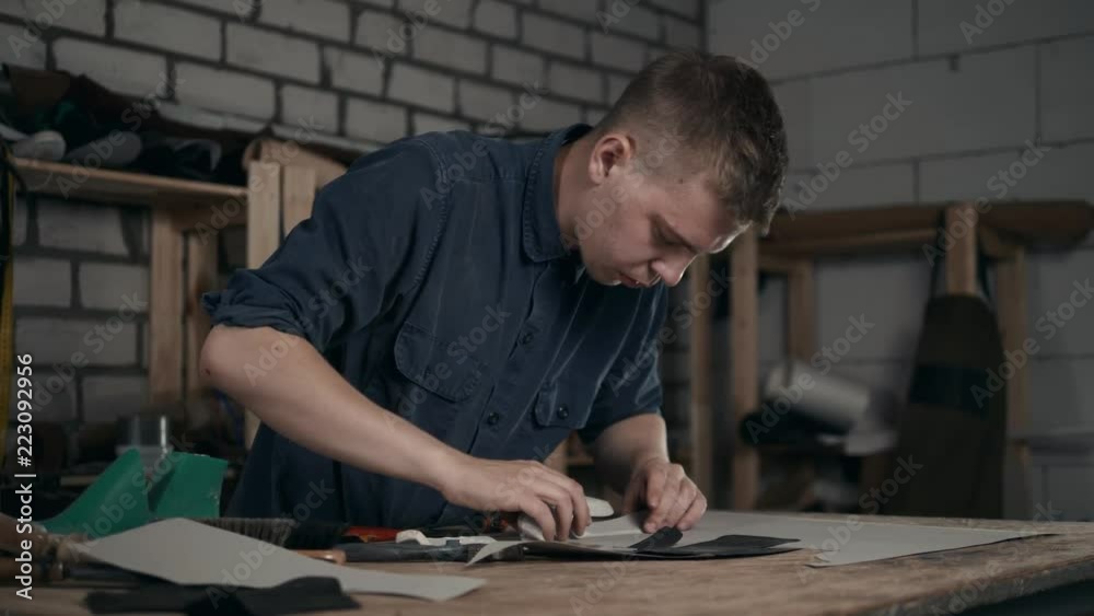 Professional male skinner, furrier working with beaver fur skin at atelier, workshop. Fashion and leatherwork concept shoemaker making boots shoes Professional male skinner, furrier working with beaver fur skin at atelier, workshop. Fashion and leatherwork concept shoemaker making boots shoes