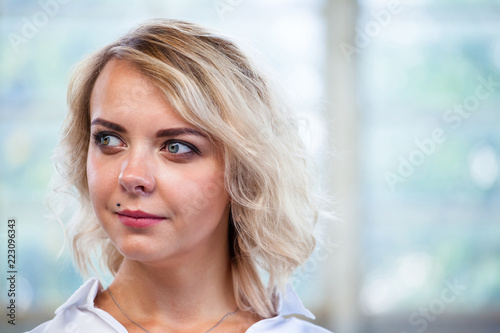 close-up portrait of a beautiful young blonde girl with a calm face and a slight smile