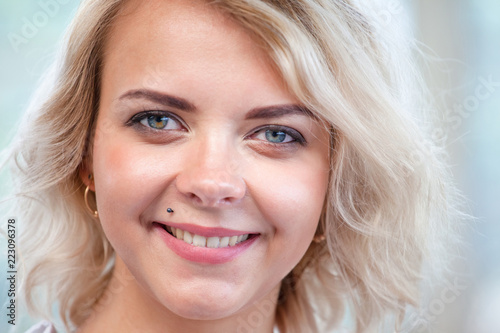 close-up portrait of a beautiful young blonde girl with a cute smile