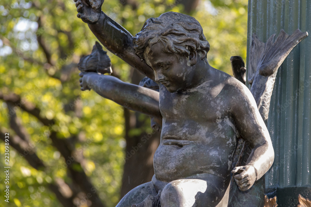 Close up child statue on Victoria Fountain Halifax Public Gardens, no people, late summer sun.