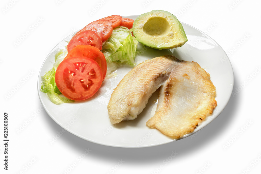 Fillet of fish served with tomato, lettuce and avocado salad. Fillet of fish served with tomato, lettuce and avocado salad.