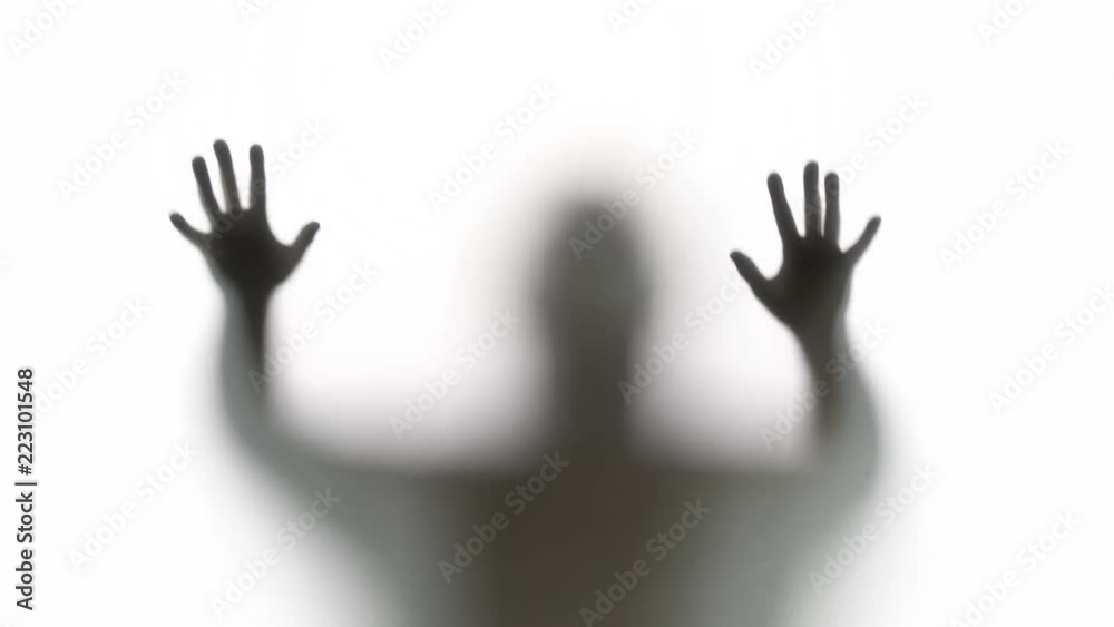 Silhouette of a zombie trying to get through a glass window. Great for Halloween.