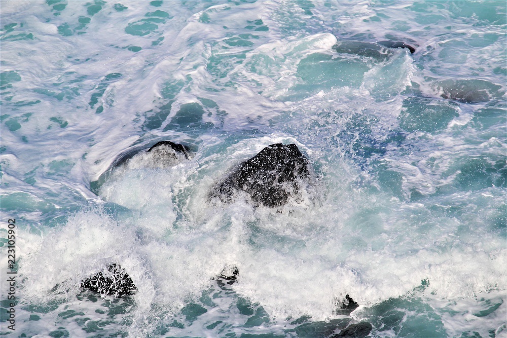 Naklejka premium Spraying wave crashed over rocks at Penguin Parade, Phillip Island, Australia 
