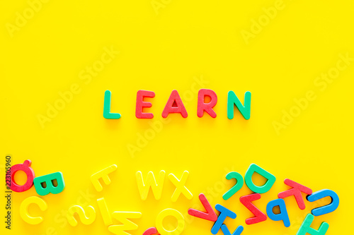 Children learn read concept. Word learn written by plastic letters on yellow background top view copy space