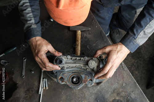 The mechanic serves the truck. Repair brake caliper. Close-up. Maintenance. Brake system. Brake spare parts. Hands working close-up. © kot500
