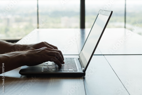freelance work or remote job. self-employed man working on laptop. hands typing on keyboard.