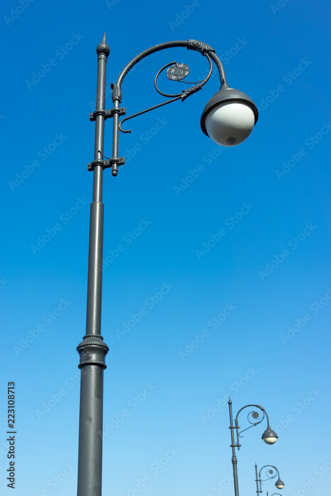 A decorated street lamp, blue sky in the background