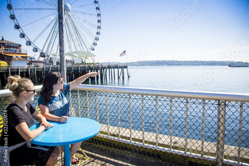 Photo Two women looking out at the Seattle harbor on a sunny day