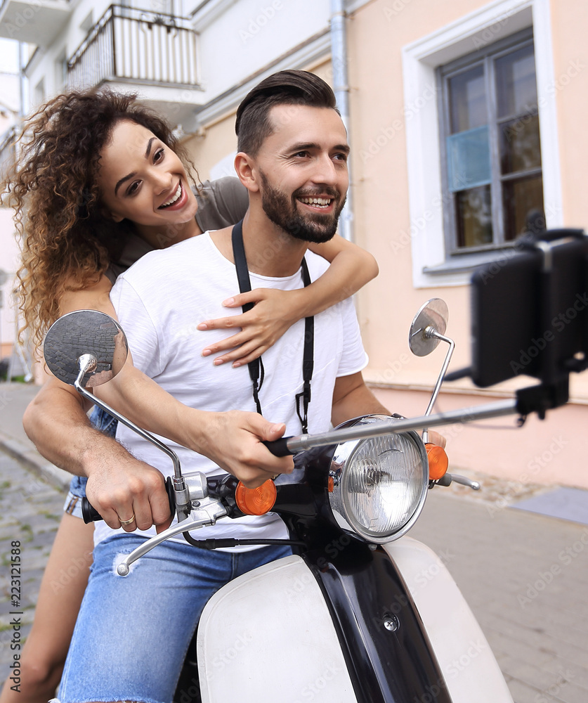Happy couple on scooter making selfie on smartphone outdoor Happy couple on scooter making selfie on smartphone outdoor