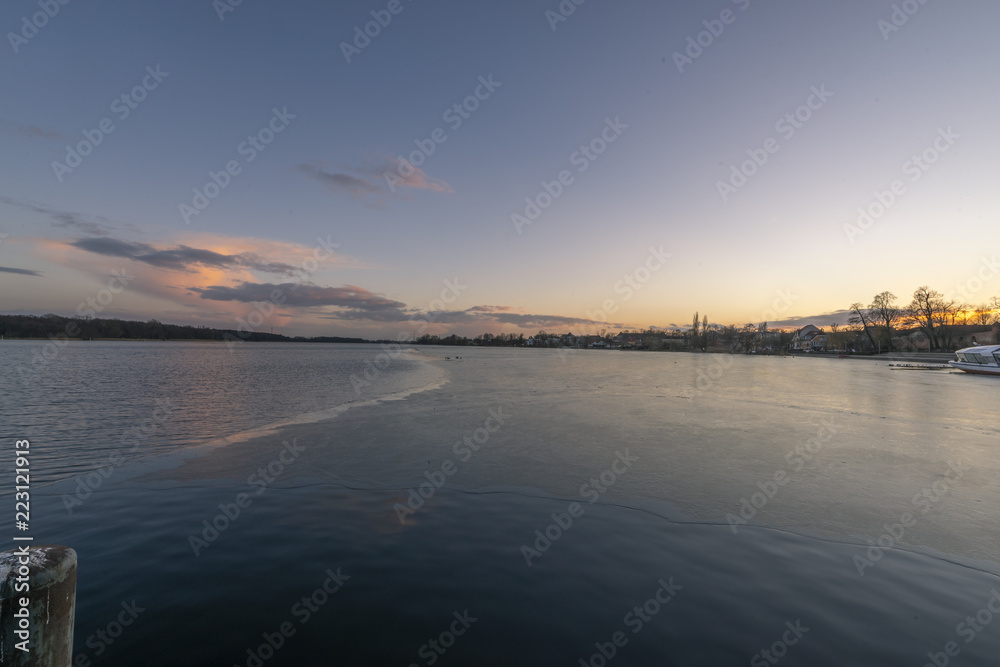 Fototapeta premium Gefrorener See zur Abenddämmerung mit Eis und Schnee