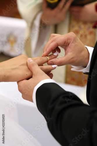 Putting wedding rings during the ceremony at the wedding .