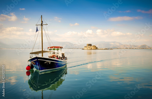 Small wooden boat transfer a group of tourists to Bourtzi island (an ancient prison). Nafplion , Greece