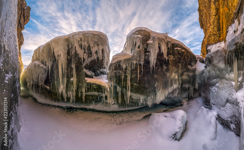 Naled on the rocks, lake skerries. Ladoga Lake of Karelia. Severe winter, frost. Cave on the shore of the island. photo