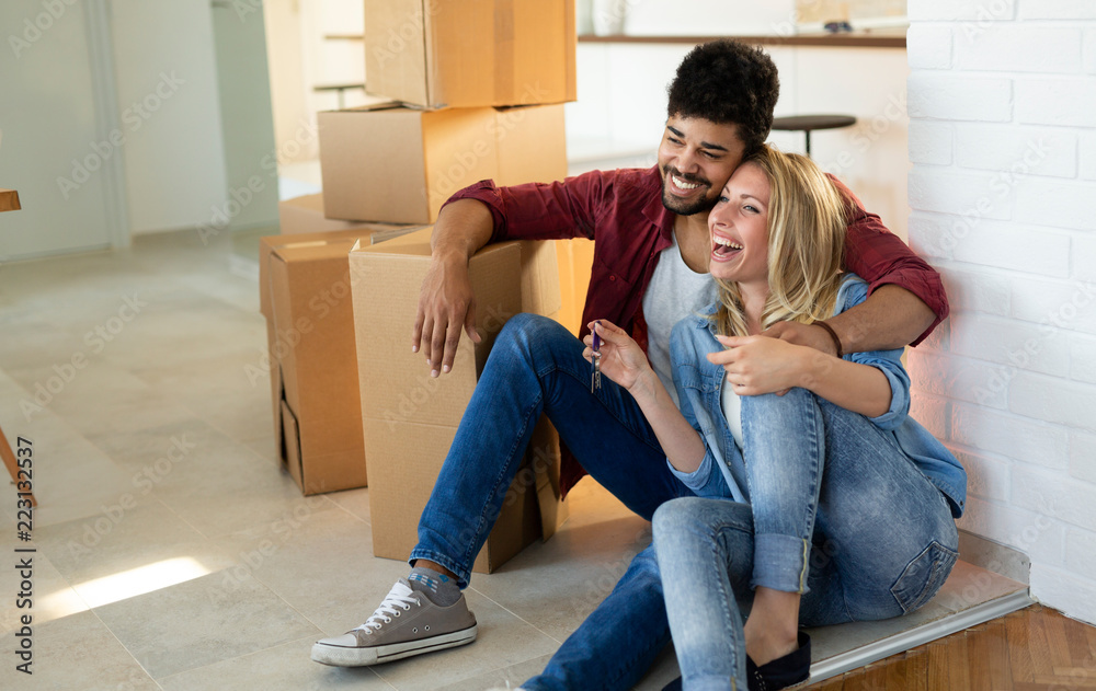 Young couple unpacking cardboard boxes at new home moving in concept Young couple unpacking cardboard boxes at new home moving in concept