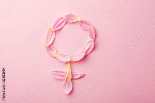 Gender Venus symbol made of beautiful flower petals on candy pink background, woman sign