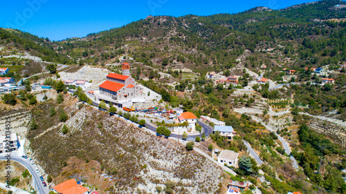 Aerial view of Agios Arsenios church, Kyperounda village, Limassol, Cyprus. Traditional landmark christian greek orthodox, ceramic tiled roof, stone bell tower architecture in Kyperounta from above photo