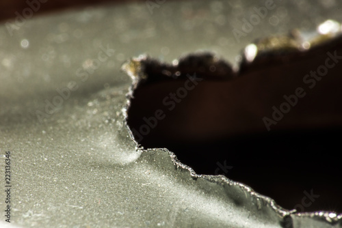 Ragged edges of an open tin surface is macro