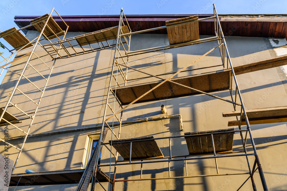 Insulation of the house with styrofoam. Scaffold on building Insulation of the house with styrofoam. Scaffold on building