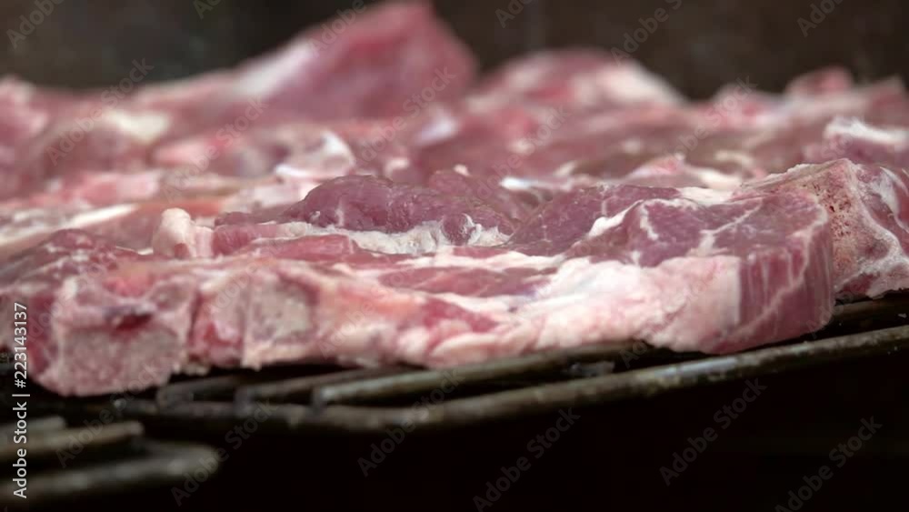 pork steak on the grill on BBQ background. Slow motion pork steak on the grill on BBQ background. Slow motion