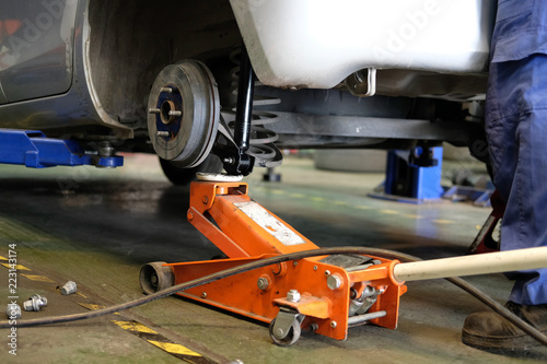 car lift up for shock absorber & spring replacement in auto repair garage