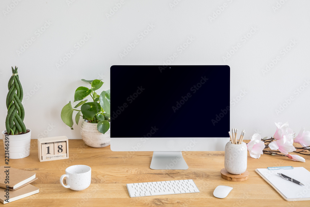 Plants, keyboard and desktop computer on wooden desk in white home office interior. Real photo Plants, keyboard and desktop computer on wooden desk in white home office interior. Real photo