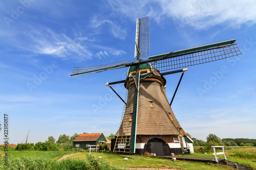 Traditional old windmill the 'Moppemolen' in Rijpwetering, the Netherlands, a historic monument and landmark in the dutch landscape on a summer day with a blue sky