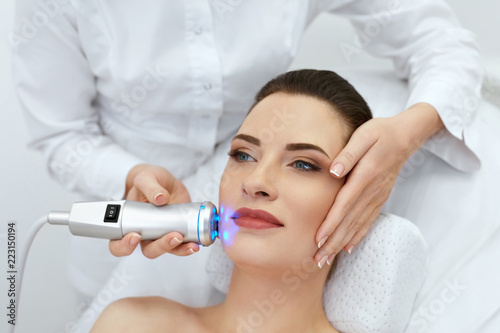 Face Skin Care. Woman Doing Blue Light Therapy At Beauty Clinic