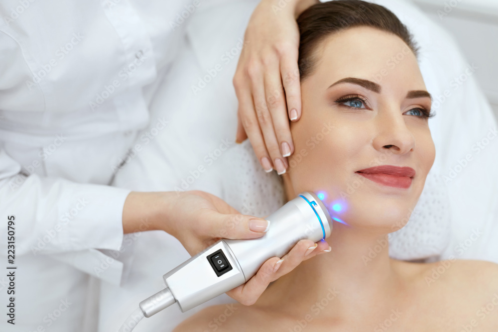 Face Skin Care. Woman Doing Blue Light Therapy At Beauty Clinic