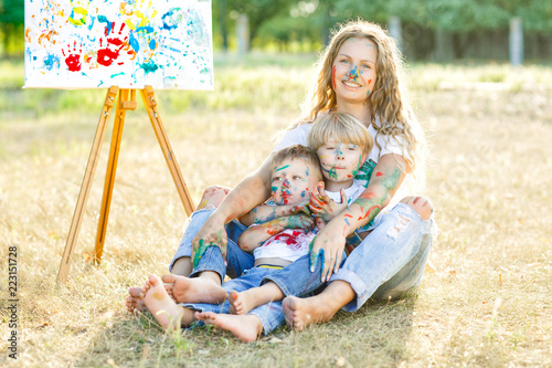 Happy family. Young pretty mother having fun with her children outdoors. Family painting