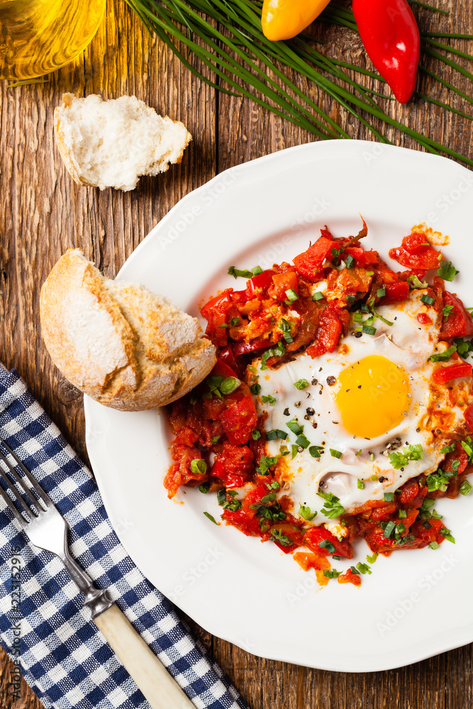Shakshouka, dish of eggs poached in a sauce of tomatoes, chili peppers, onions Shakshouka, dish of eggs poached in a sauce of tomatoes, chili peppers, onions