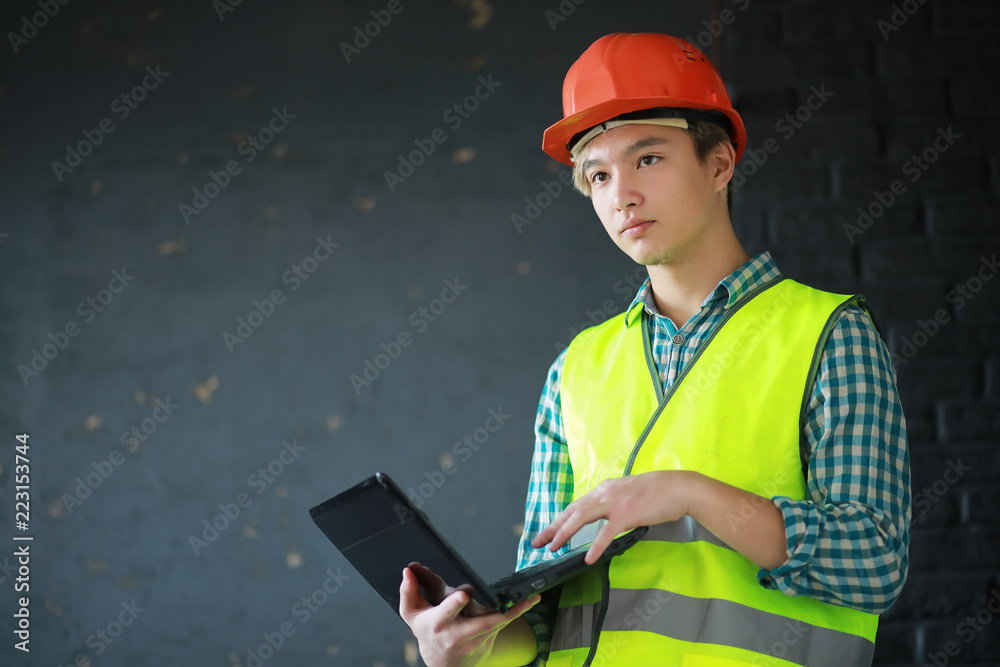 Fototapeta premium Asian man in protective helmet and construction waistcoat