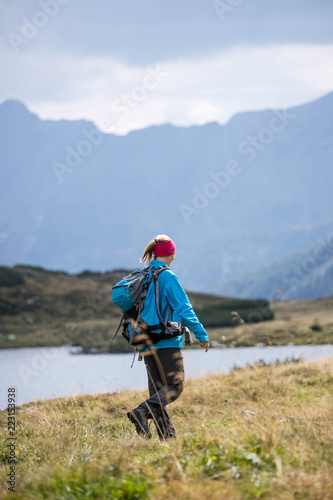 Junge Frau mit Rucksack wandert in den Alpen, Alpensee