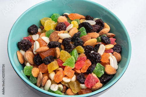 dried fruits and nuts in a green plate on a white background, isolate