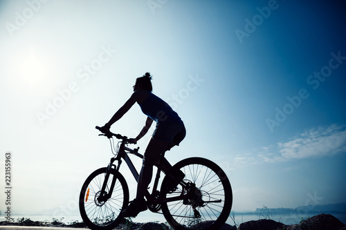 Cycling woman riding mountain mike on sunrise seaside © lzf