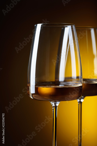 Glasses of white wine on a yellow background.