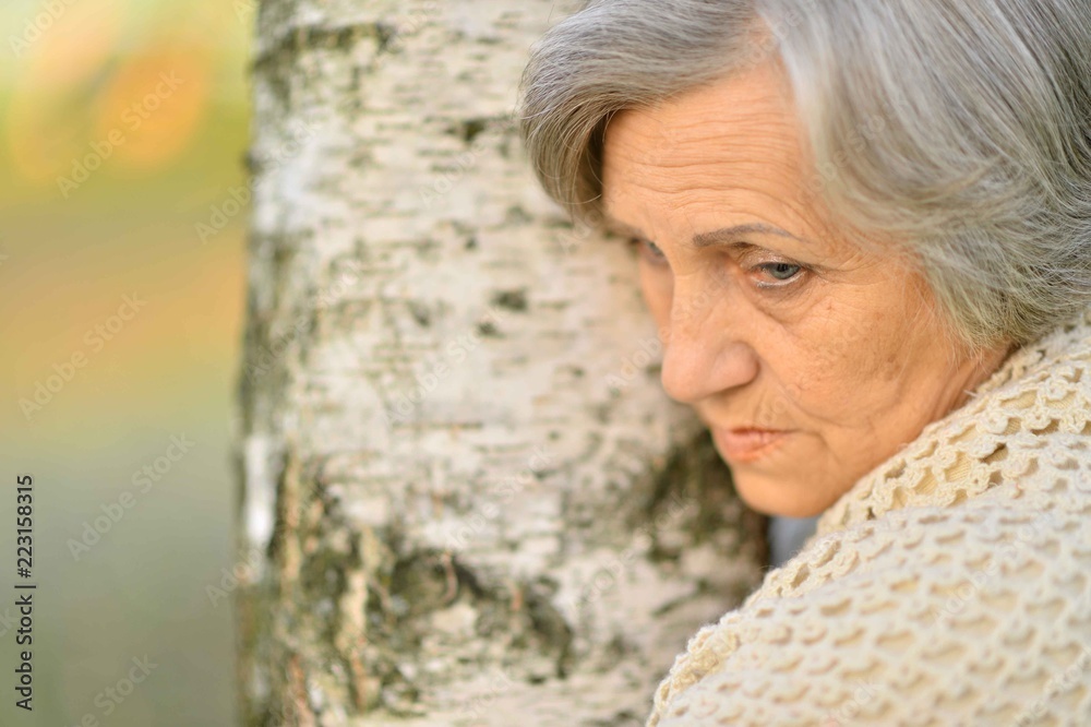 Portrait of senior woman by the tree Portrait of senior woman by the tree