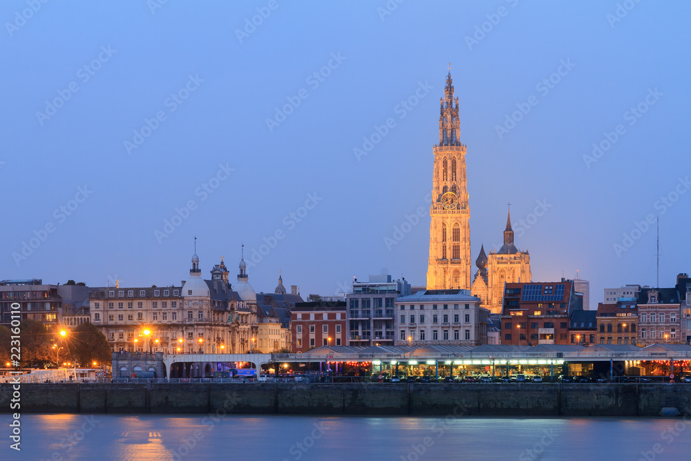 Fototapeta premium Beautiful cityscape of the skyline of Antwerp, Belgium, during the blue hour seen from the shore of the river Scheldt 