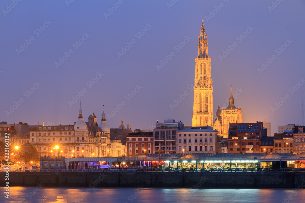 Naklejka premium Beautiful cityscape of the skyline of Antwerp, Belgium, during the blue hour seen from the shore of the river Scheldt 