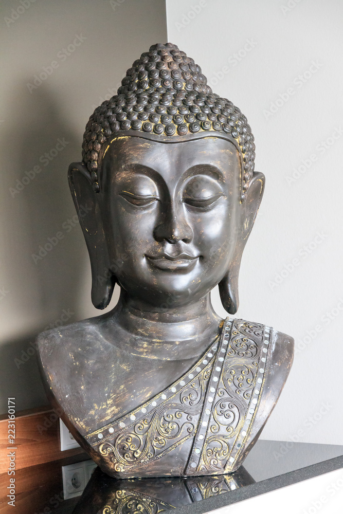 Beautiful grey bust statue of some kind of Asian Buddhist figure with a grey and white background
