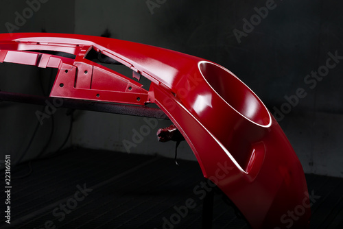 Photos Auto body repair series: Red bumper being painted in paint booth
