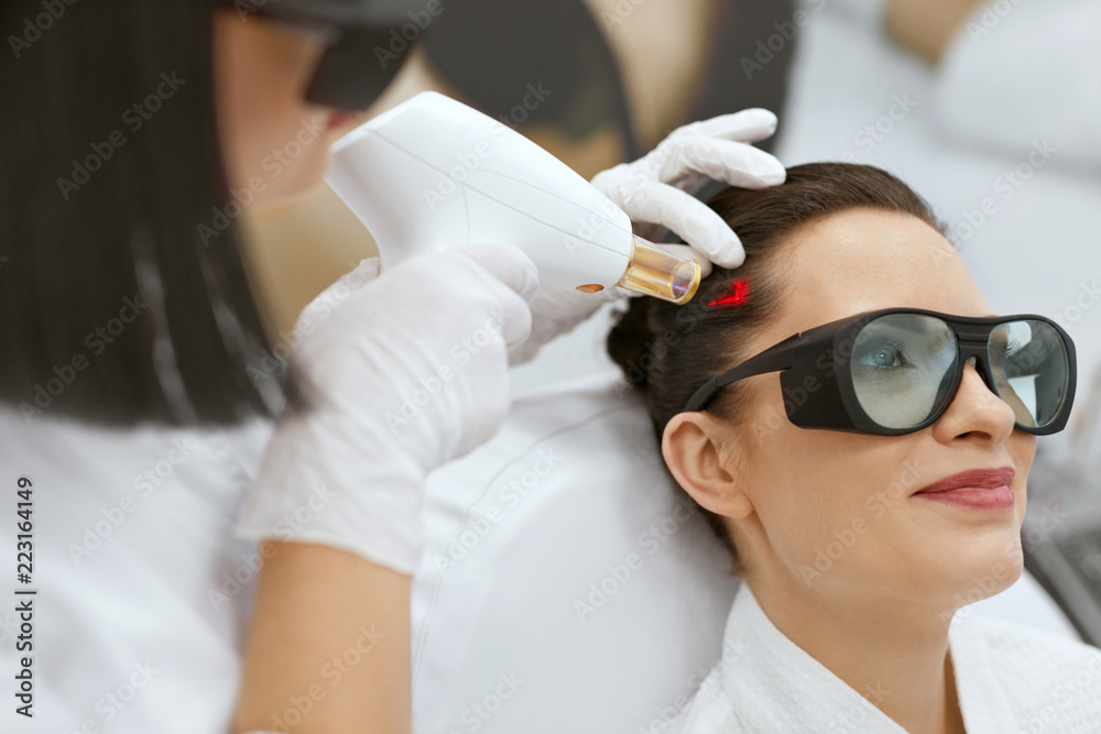 Naklejka premium Cosmetology. Woman At Hair Growth Laser Stimulation Treatment