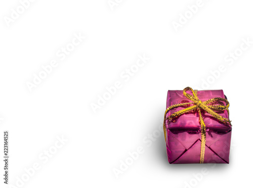 Pink gift box with a golden color bow isolated on white background