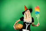 Surprised housekeeper wife with pumkin play and posing. Halloween wide banner with Sexy girl housekeeper. Costumes and witch hats.