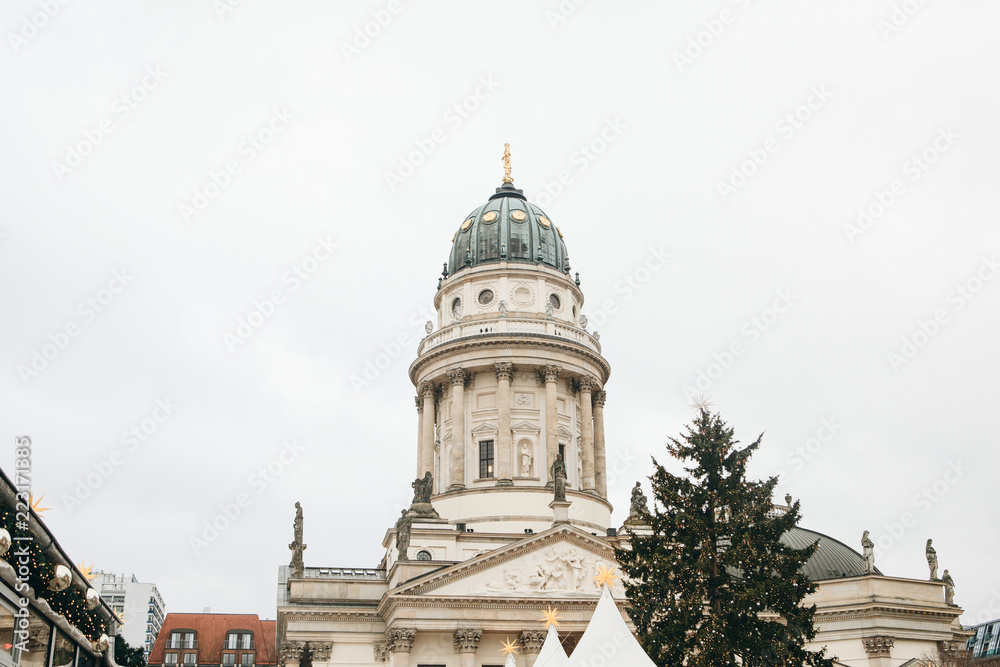 French Cathedral or Franzoesischer Dom in Berlin, Germany. Decorated Christmas tree near by. Celebrating Christmas or New Year.