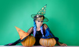 Emotional young women in halloween costumes on halloween party over green background. Looking camera. Holidays, decoration and party concept.