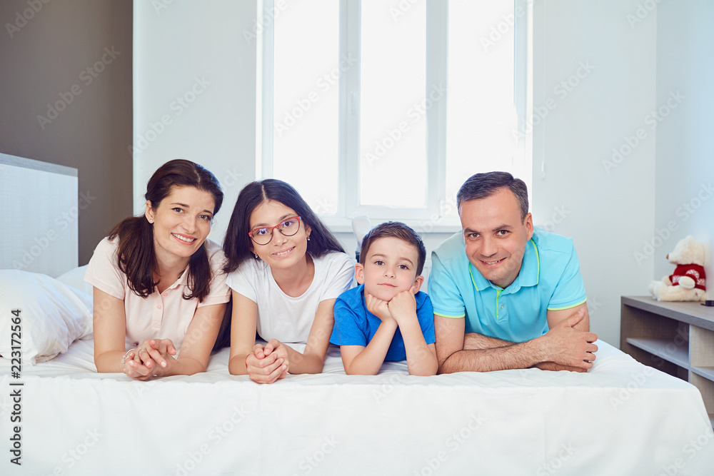 Portrait of happy family lying in bedroom. Portrait of happy family lying in bedroom.