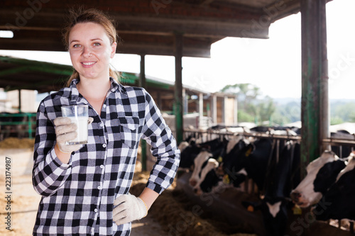 Woman with glass of milk on farm