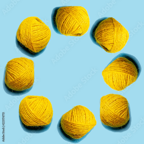 水色背景の上に円形に置いた黄色の麻糸 