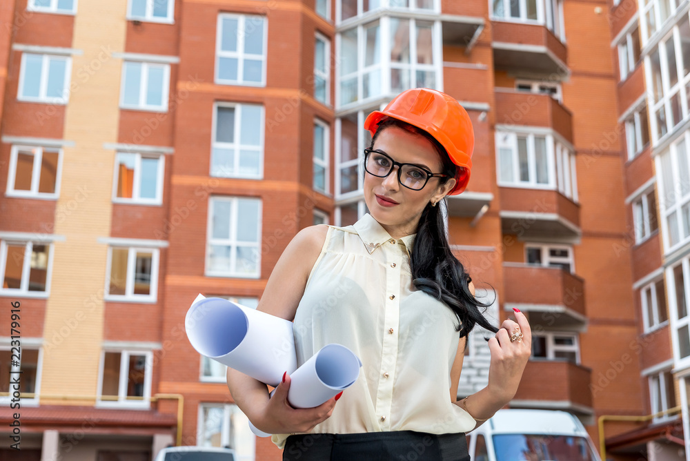 Beautiful architect with rolls on construction site background Beautiful architect with rolls on construction site background